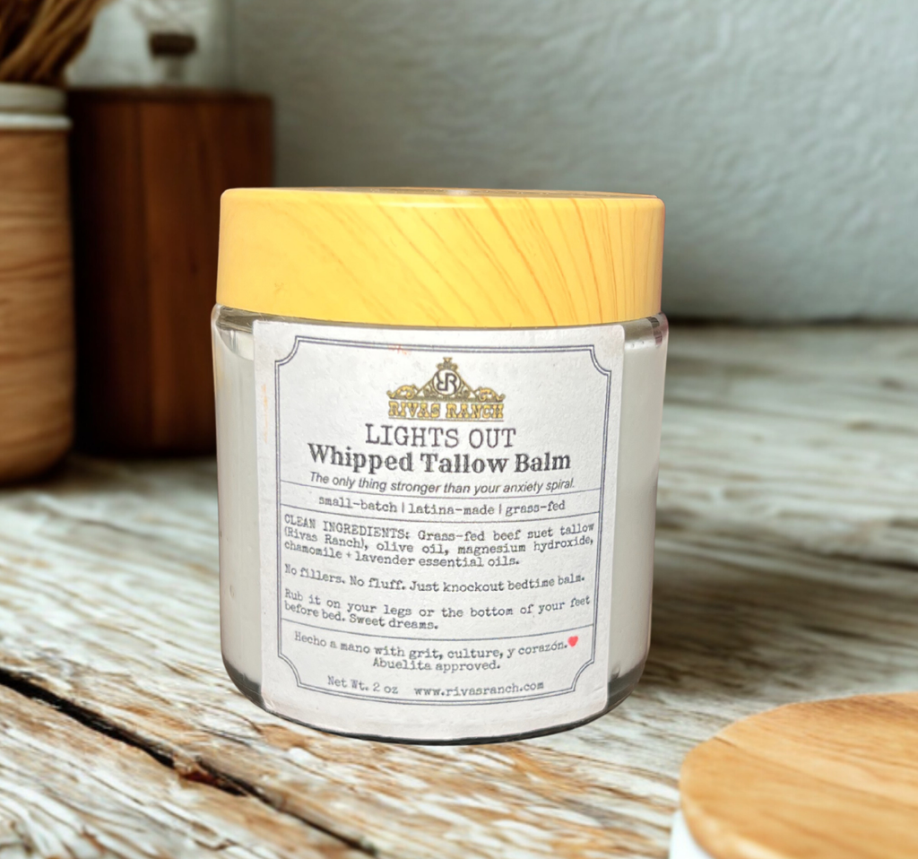 Jar of 'Lights Out Whipped Tallow Balm' with a yellow lid on a wooden surface.