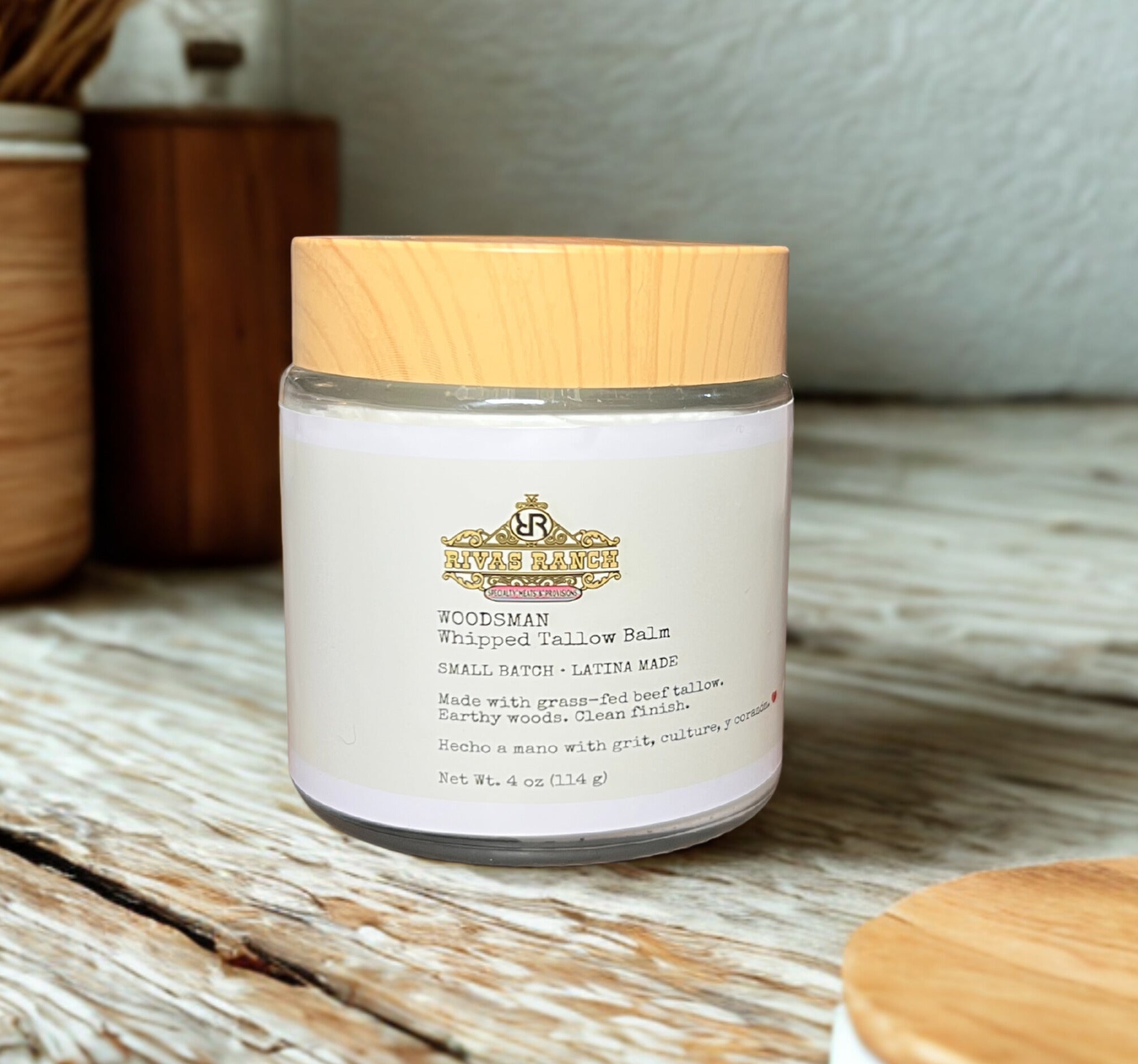Jar of Woodsman Whipped Tallow Balm with wooden lid on rustic wooden surface
